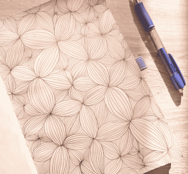 Dessin DIY zen art floral en noir et blanc dans un carnet, motif répétitif relaxant et créatif.